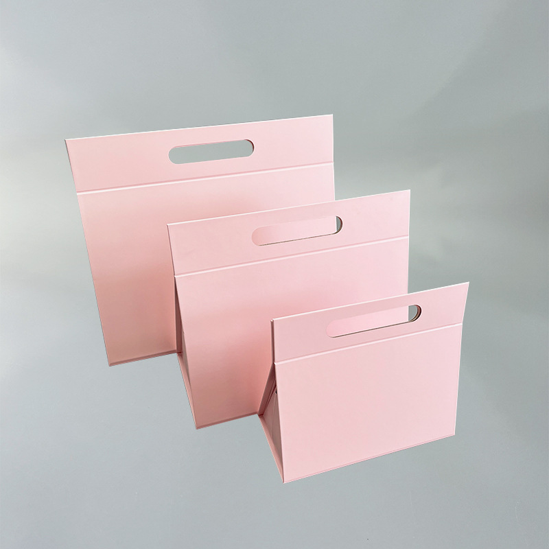 A set of three different sized bespoke triangular collapsible packaging boxes in pink.